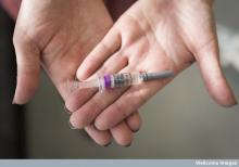Hands holding a vaccine
